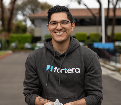Fortera team member wearing a Fortera branded sweatshirt and smiling